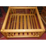 A contemporary light oak square coffee table, having glass inset top and slatted undertier, w.85cm