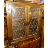 A pair of contemporary moulded oak and lead glazed double door low bookcases, each w.91cm