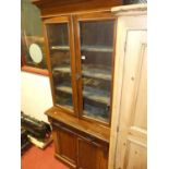 A late Victorian walnut bookcase cupboard, having twin glazed upper doors, width 92cm
