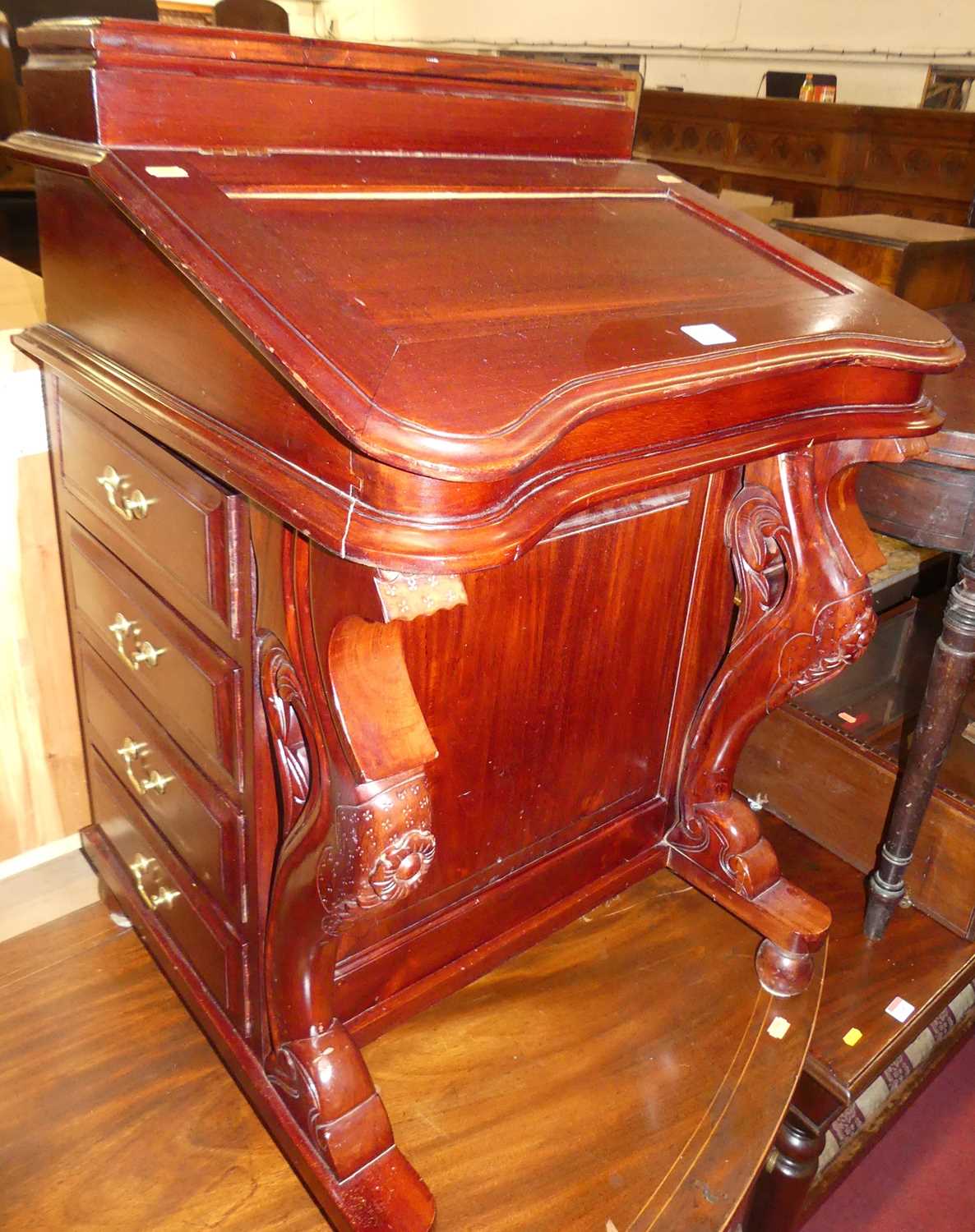 A reproduction stained hardwood slopefront davenport, having twin hinged upper compartments over