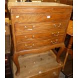 A contemporary teak serpentine front dressing chest, of three drawers, having hinged upper