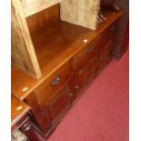 A contemporary joined oak sideboard, having three frieze drawers over conforming recess panelled