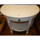 A contemporary Ducal white painted pine demi-line two-tier side table, w.90cm