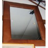 A modern wall mirror in tan leatherette surround 118x88cm