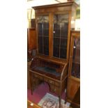 A circa 1900 mahogany secretaire cylinder bookcase, the twin glazed upper doors over fitted cylinder