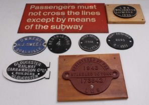 Tray containing seven cast iron wagon plates and a BR aluminium ‘Passengers must not cross the