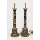 A pair of reproduction black and gilt painted table lamps, in the form of Doric columns, decorated