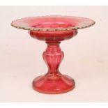 A 19th century ruby glass comport, gilt decorated with trailing vines, standing upon a circular