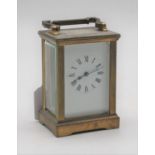 A 20th century lacquered brass cased carriage clock having an enamel dial with Roman numerals,