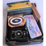 A box of miscellaneous items to include albums of cigarette cards and vintage tins