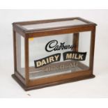 A 20th century oak glazed advertising table top display cabinet for Cadbury's Dairy Milk