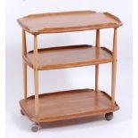 An Ercol light elm round cornered three-tier tea trolley, having raised sides and on roller castors,