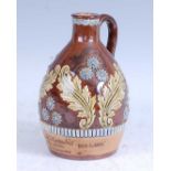 An early 20th century Royal Doulton Lambeth stoneware whisky carafe, relief decorated with daises