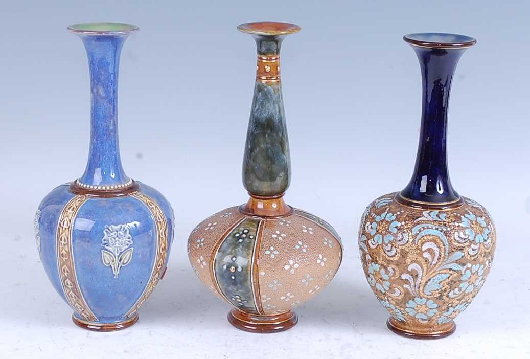 A collection of three Royal Doulton Lambeth stoneware bottle vases, each with a flared rim above a