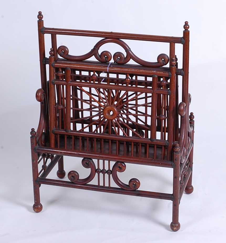 An Arts & Crafts turned mahogany twin division magazine stand, having opposing hinged open and close