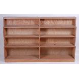 In the manner of Heal's - a 1930s limed oak twin flight waterfall open bookshelf, raised on