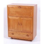 An Ercol light elm Windsor 469 portable drinks cabinet, having fall-front compartment over twin