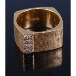 A 1970s 18 carat gold fashion ring, having raised panel set with eight diamond points, maker JA,