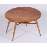 A 1960s Ercol light elm low single dropflap occasional table, having gateleg action, h.41cm, dia.