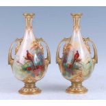 A pair of 1910 Royal Worcester porcelain vases, each of pear shape and flanked by twin handles,