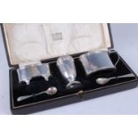 A George V silver three-piece cruet set, in fitted case, comprising an open table salt, lidded