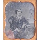 A Victorian leather cased daguerreotype, depicting a three-quarter length portrait of a woman seated
