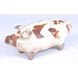 An 18th century Dutch cream and brown slip glazed earthenware money box, in the form of a pig,