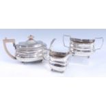 A late Georgian silver three-piece tea set, comprising angular wooden handled teapot with hinged lid
