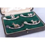 A cased set of four Mappin & Webb silver menu stands, each as a wishbone featuring a single