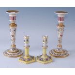 A pair of 19th century French hard paste porcelain table candlesticks, each hand painted with