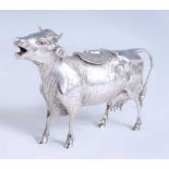 A continental mid 20th century finely chased silver cow creamer, having red paste set eyes and