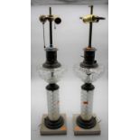 A pair of converted pressed glass oil lamps, each mounted upon a polished hardstone plinth, height
