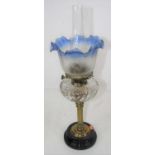 A late 19th century brass oil lamp, the blue tinted acid etched shade above a clear wrythen glass