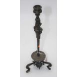 A bronze table candlestick, the stem in the form of a classical bust standing upon three sandal clad