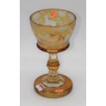 A late 19th century Bohemian amber glass goblet, the ogee bowl with wheel engraved decoration of a