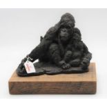 A bronzed model of a gorilla and its baby, mounted upon an oak plinth, height 24cm