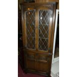 A contemporary Old Charm moulded oak freestanding corner cabinet, with twin lead glazed upper doors