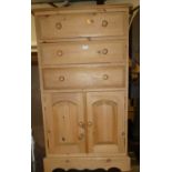 A modern pine tallboy chest of three long drawers over twin lower cupboard doors, width 66cm