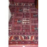 A Persian woollen red ground rug, the square central ground with various panels of geometric