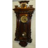 An early 20th century walnut Vienna droptrunk wall clock, with pendulum and winding key, h.90cm