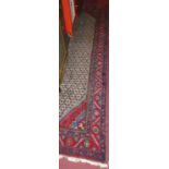 A Persian woollen Bokhara hall runner, the repeating central ground within trailing tramline