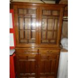 A circa 1900 oak bookcase cupboard, having twin glazed upper doors enclosing adjustable shelves,