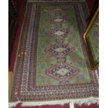 A Persian woollen green ground Shiraz rug, 195 x 126cm