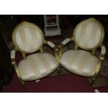 A pair of French Louis XVI style carved giltwood framed fauteuils, having striped upholstery,