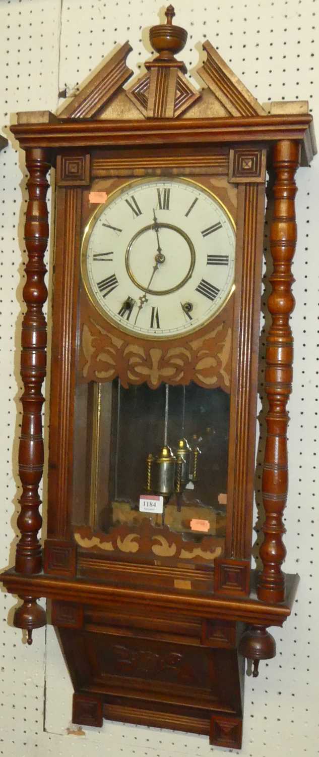 A circa 1900 walnut Vienna droptrunk wall clock, with ring turned columns (with pendulum), w.98cm