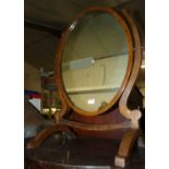 A circa 1900 mahogany oval swing dressing mirror, having twin detachable candle sconces