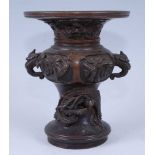 A far eastern bronze vase, the flaring rim cast with a preying deity above a mythical creature