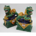 A pair of reproduction Chinese hollow moulded models of Temple Dogs, glazed in shades of green,