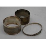 A George V silver napkin ring, Birmingham 1915; together with one other; and a white metal bangle (