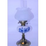 A 20th century oil lamp having an opalescent glass shade with blue & white ceramic font, decorated